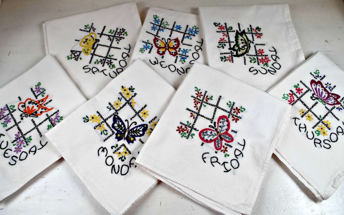 Two dish towels with butterflies hand embroidered on them and the words Wednesday and  Thursday