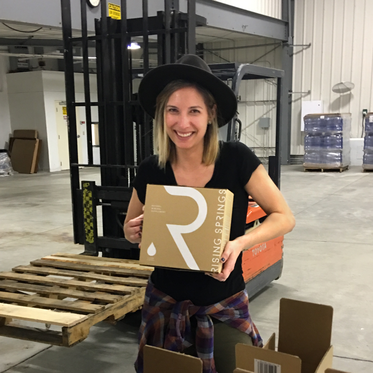 Rising Springs Project Manager holding boxed water Rising Springs Project Manager holding boxed water