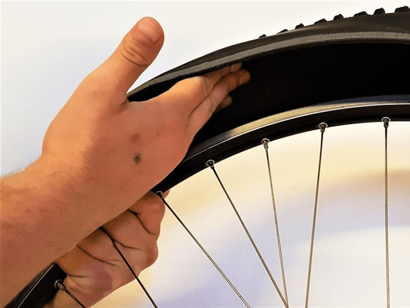 Beim Fahrradschlauch flicken Fahrradmantel und Felge auf Gegenstände und Beschädigungen prüfen