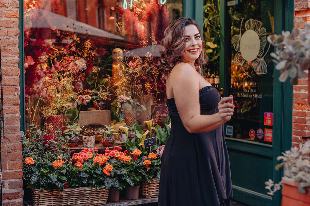 Tegan wearing a Diane Kroe Bubble Dress, standing in front of a flower shop