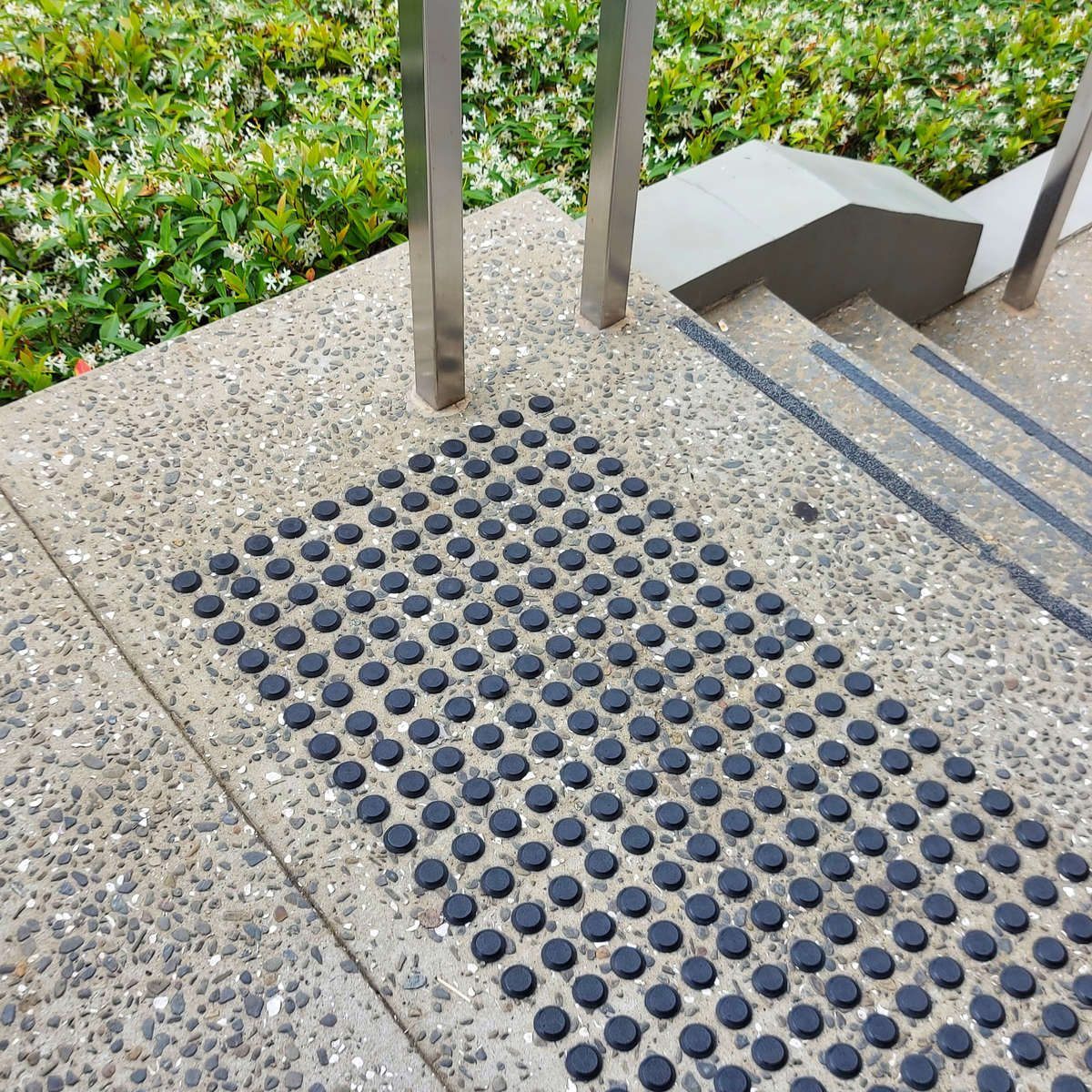 TacPro black polyurethane tactile indicators installed at top of stairs.