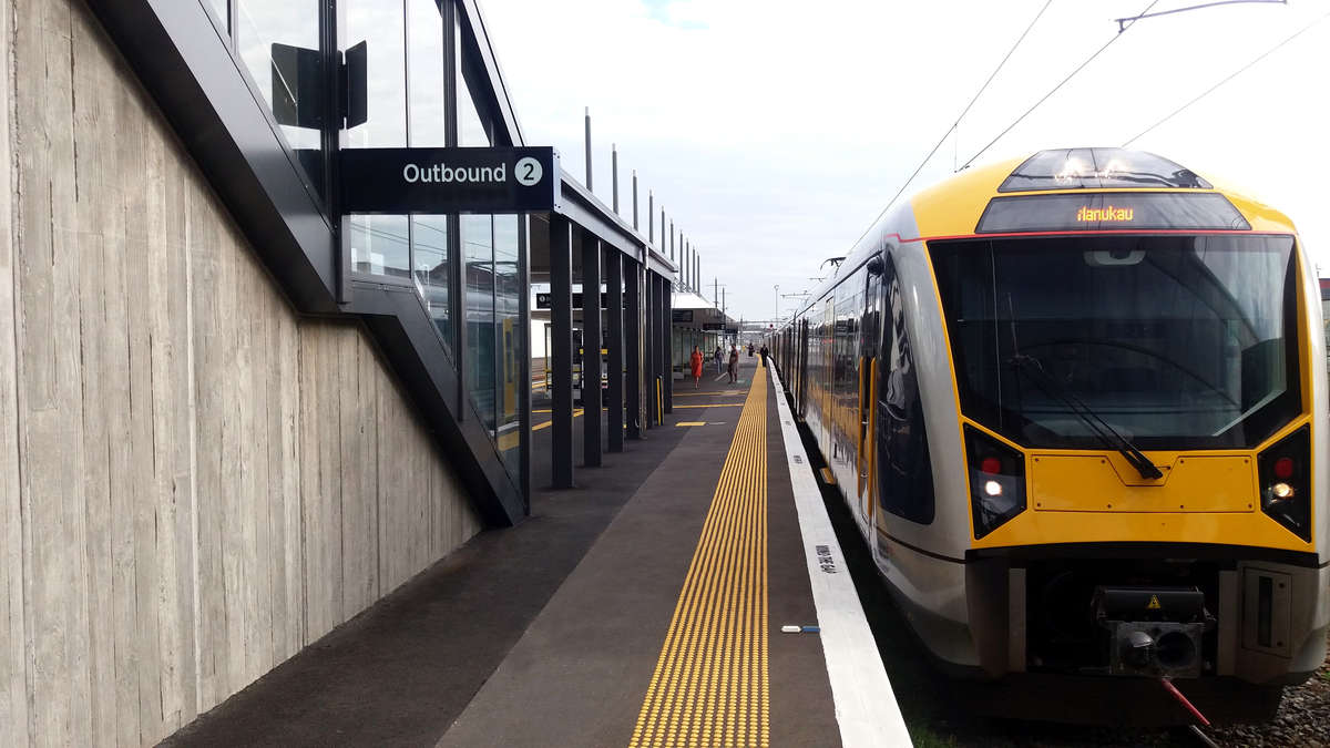 Yellow polyurethane tactile indicators on asphalt on train station platform edge