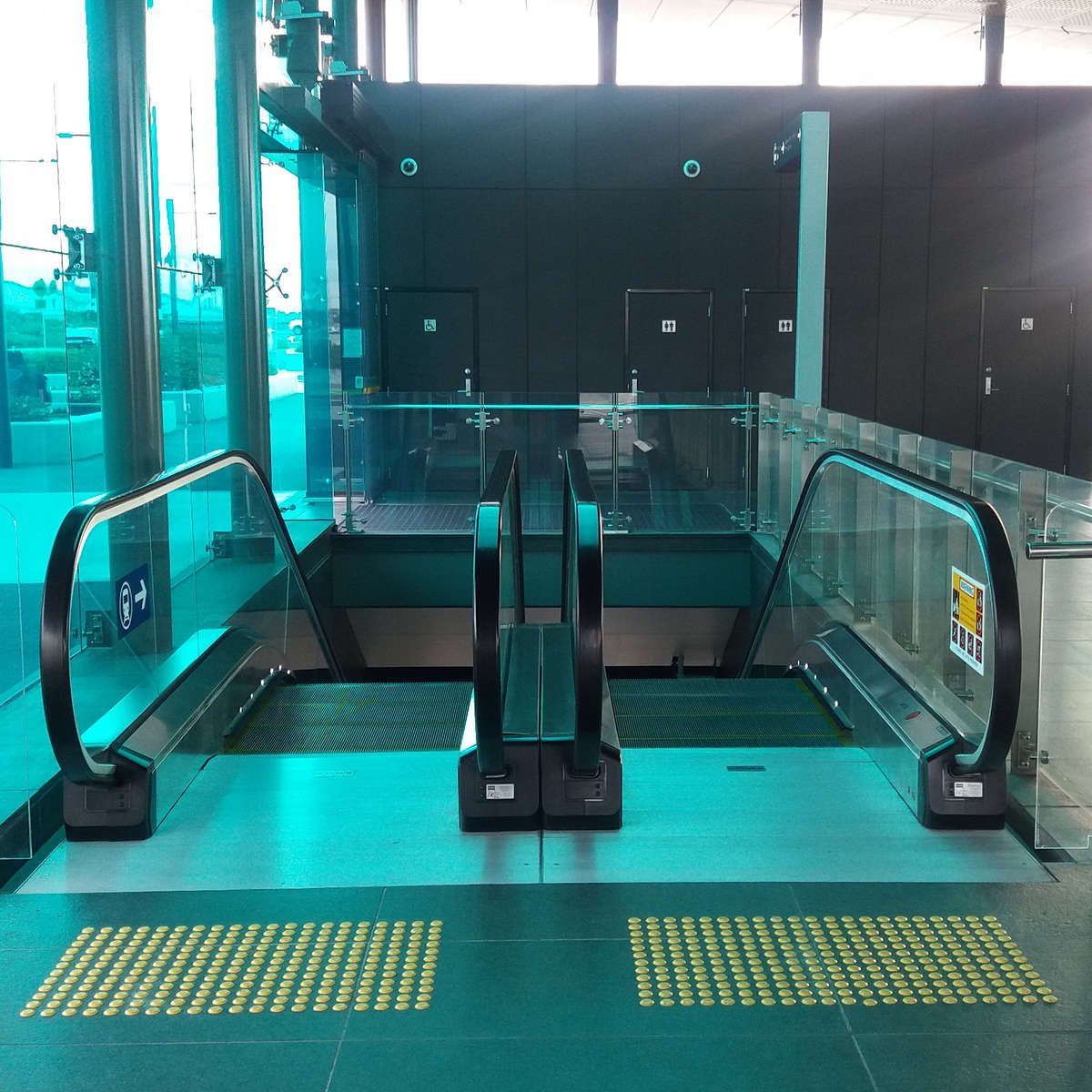 TacPro yellow polyurethane tactile indicators on bluestone tiles at top of train station escalators
