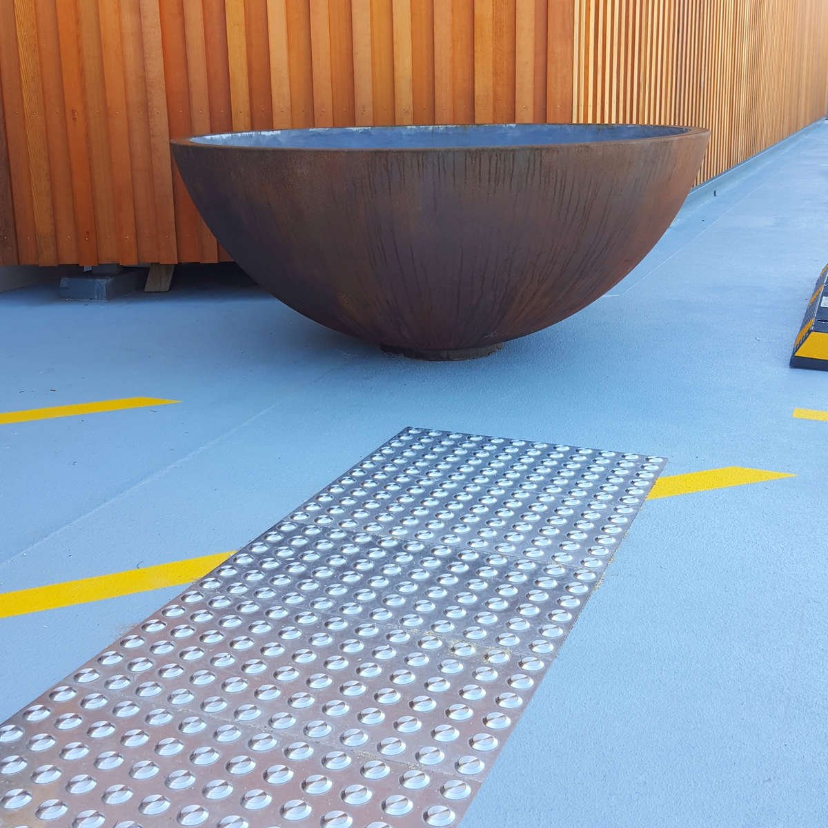 TacPro stainless steel tactile indicators on painted membrane in carpark