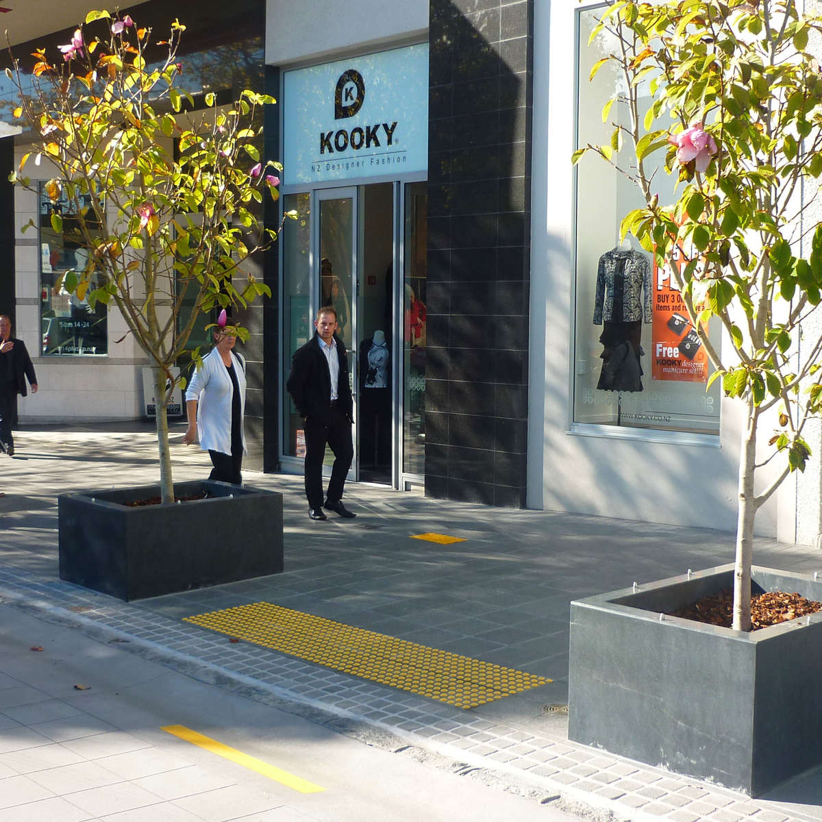 TacPro yellow polyurethane tactile indicators installed on bluestone tiles at a courtesy pedestrian crossing.