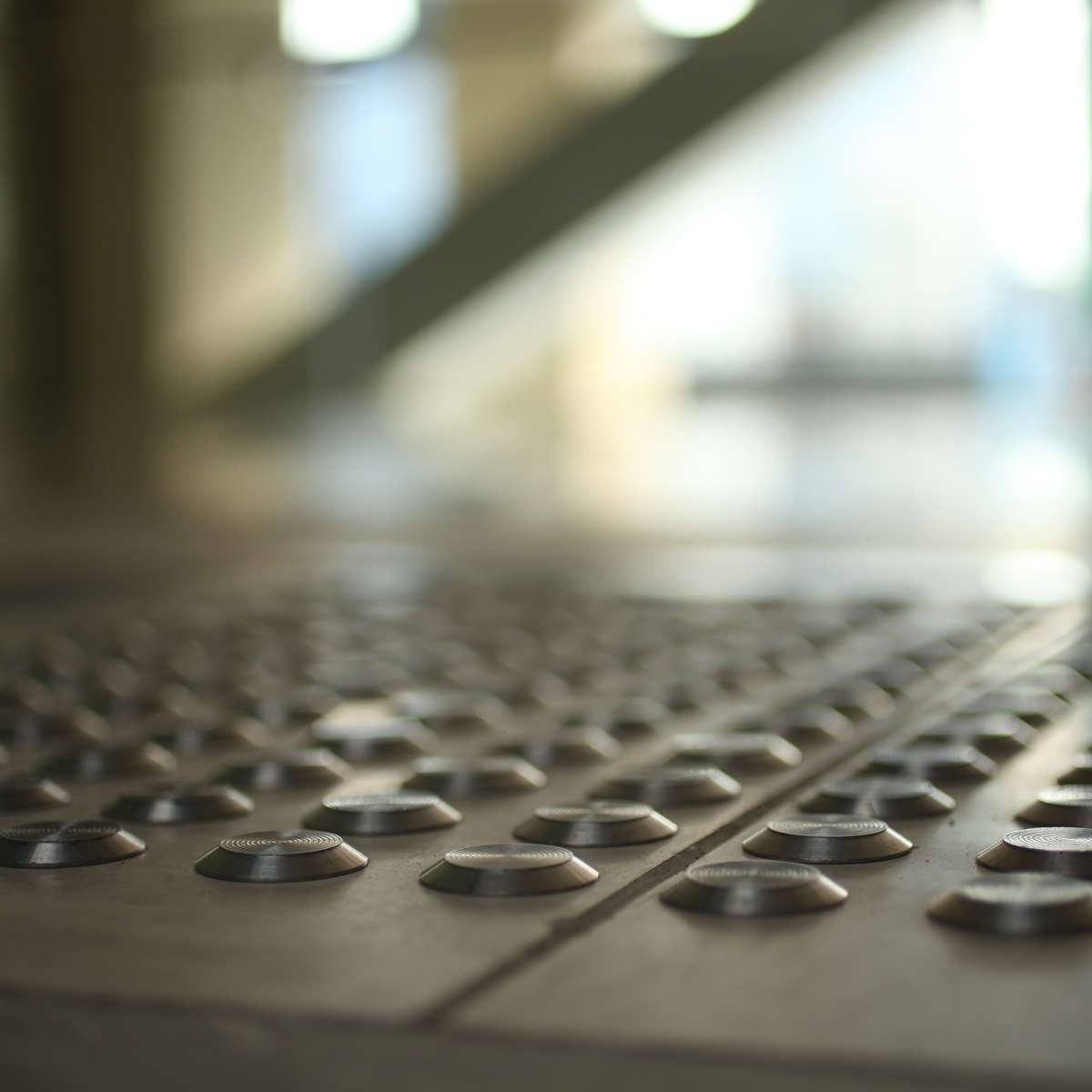 Close-up of TacPro stainless steel tactile indicators installed on tiles