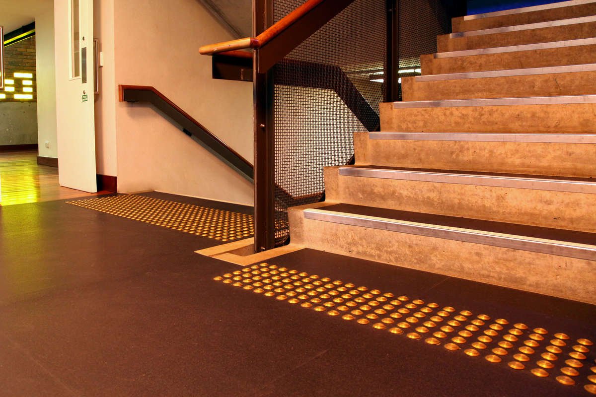 TacPro brass tactile indicators on lino at staircase landing