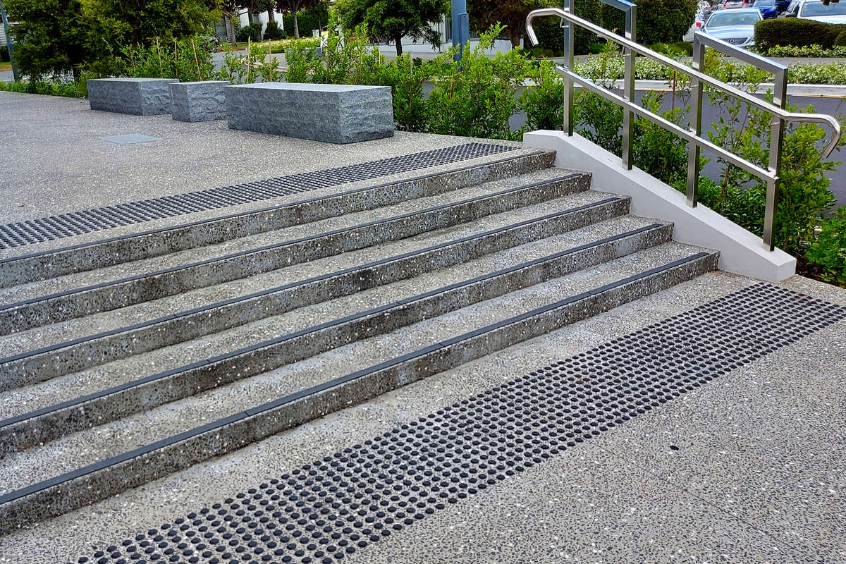 TacPro black polyurethane tactile indicators installed at top and bottom of stairs.