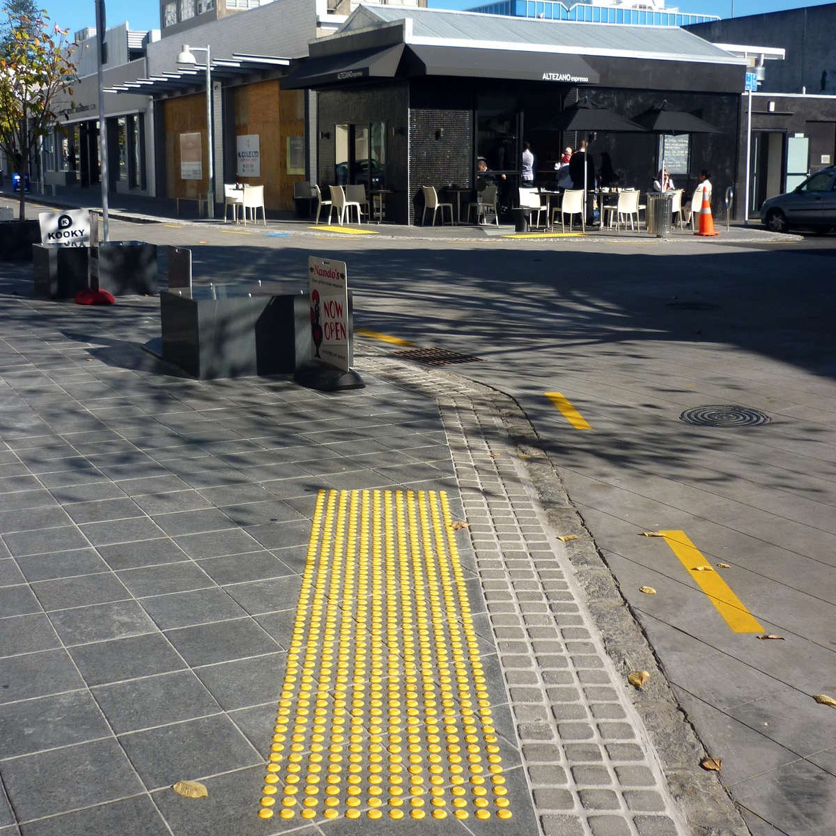 TacPro yellow polyurethane tactile indicators installed on bluestone tiles at a courtesy pedestrian crossing (3)