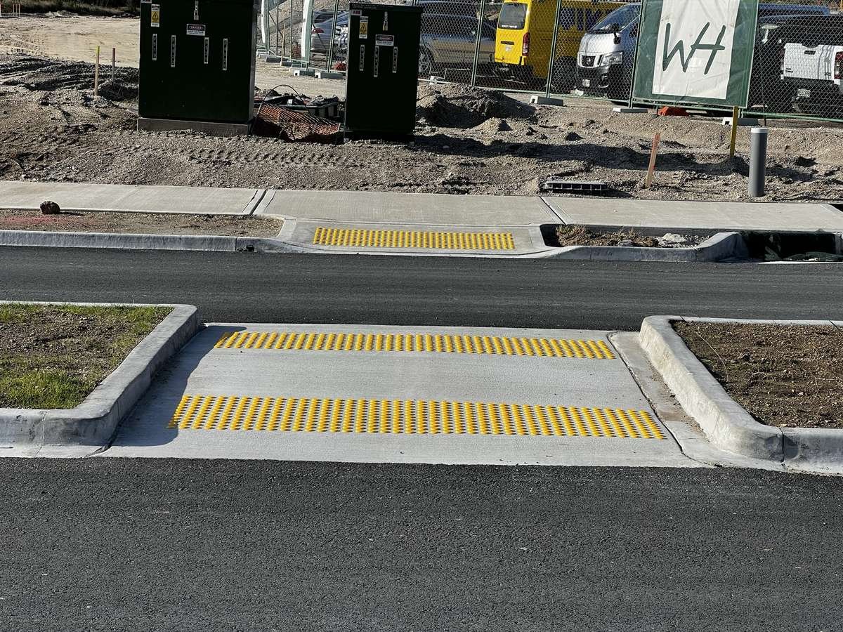 TacPro yellow polyurethane tactile indicators on concrete at a new subdivision pram crossing and mid-block