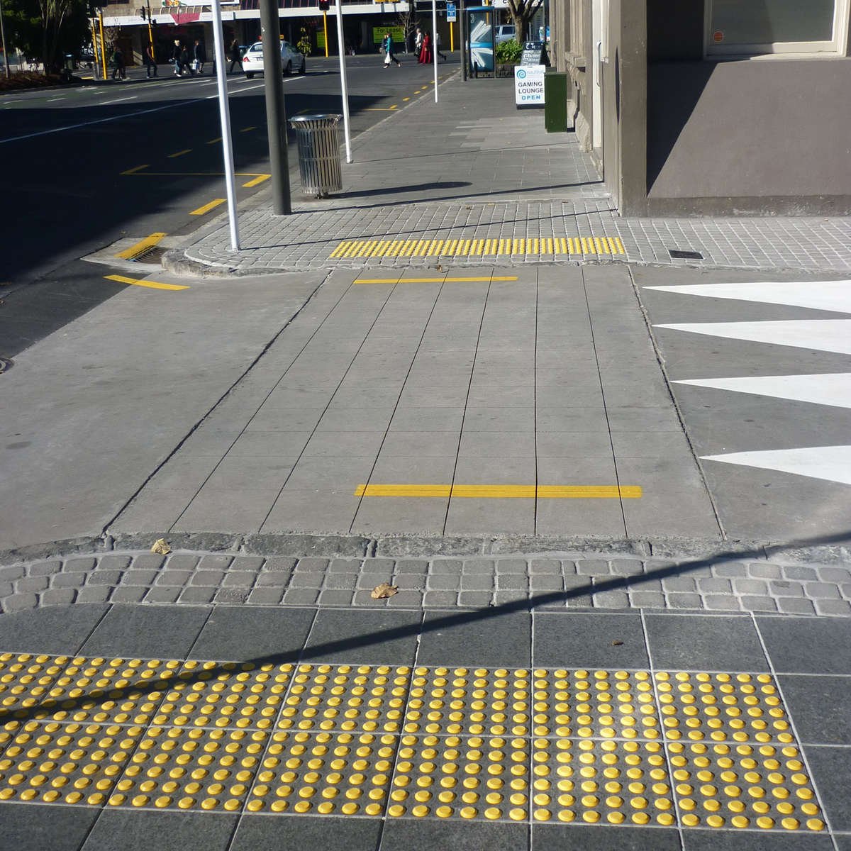 TacPro yellow polyurethane tactile indicators installed on bluestone tiles at a courtesy pedestrian crossing (2)