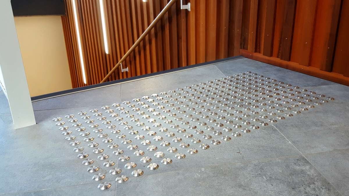 TacPro stainless steel tactile indicators on bluestone tiles at top of stairs