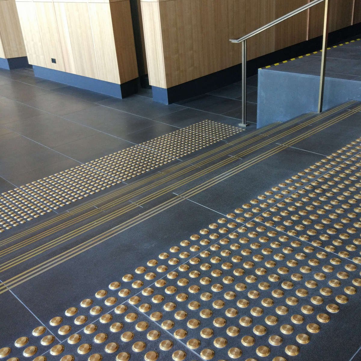 TacPro brass tactile indicators on bluestone at the top and bottom of stairs