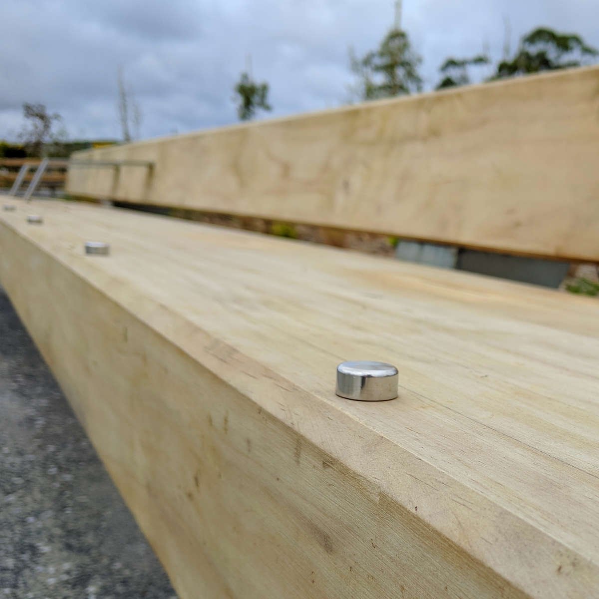 Close-up of TacPro stainless steel skateboard deterrents on timber seating 