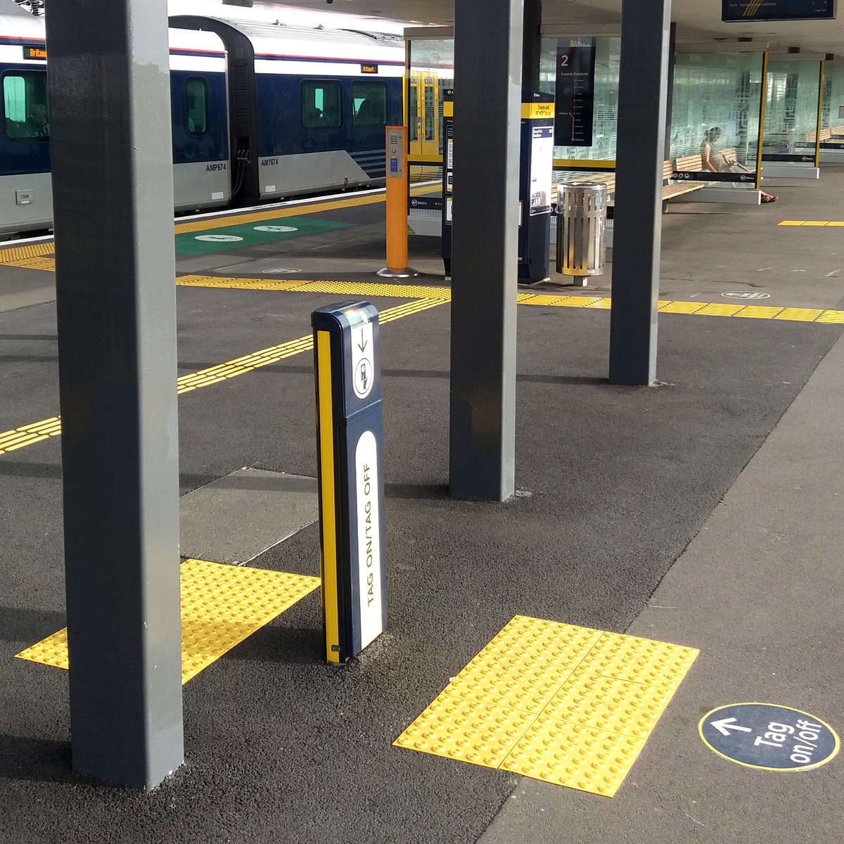 Yellow polyurethane tactile indicators on concrete at train station payment machine