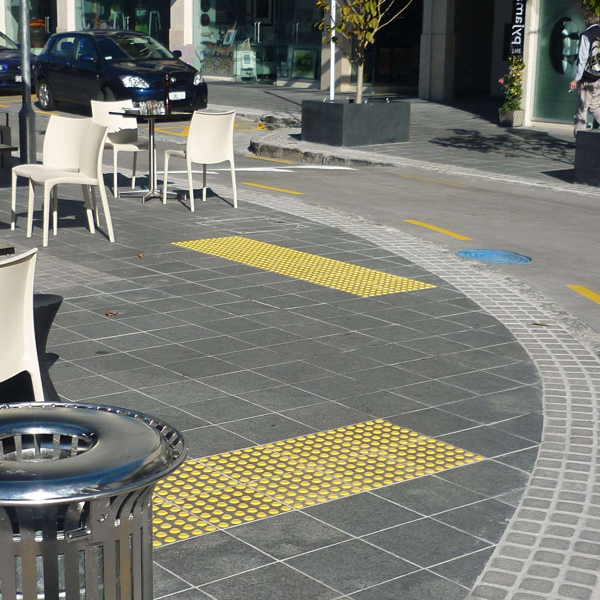 TacPro yellow polyurethane tactile indicators installed on bluestone tiles at courtesy pedestrian crossings.