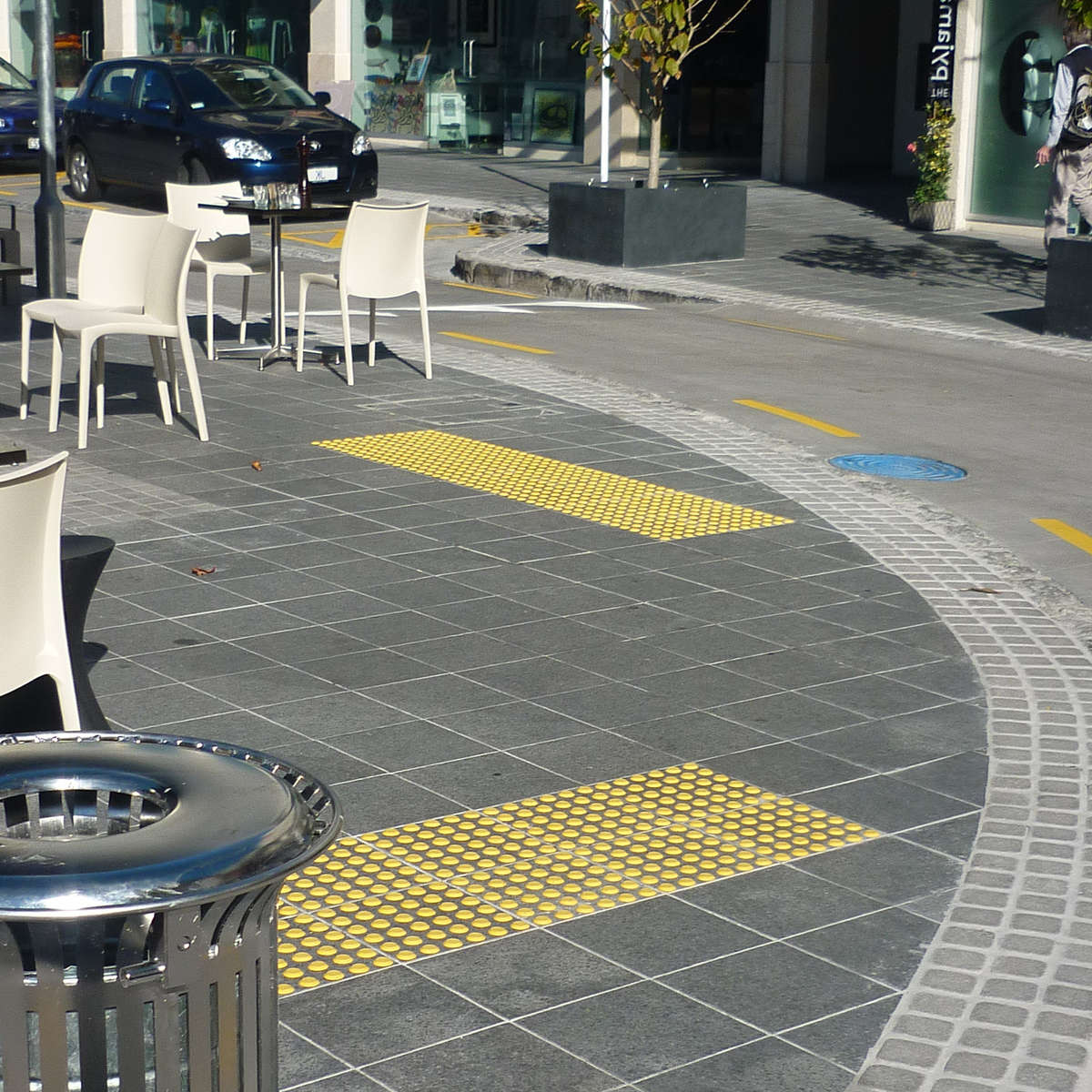 TacPro yellow polyurethane tactile indicators installed on bluestone tiles at courtesy pedestrian crossings.