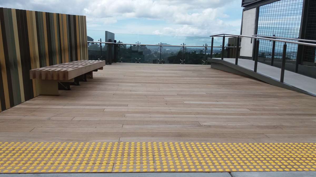 Yellow polyurethane tactile indicators on timber decking