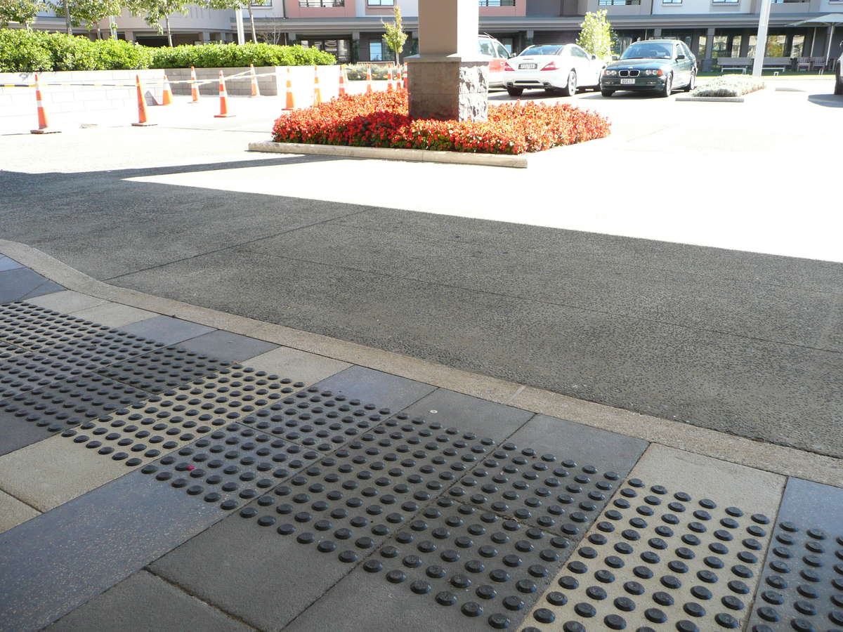 TacPro black polyurethane tactile indicators installed on bluestone tiles at zebra crossing outside retirement village (3)