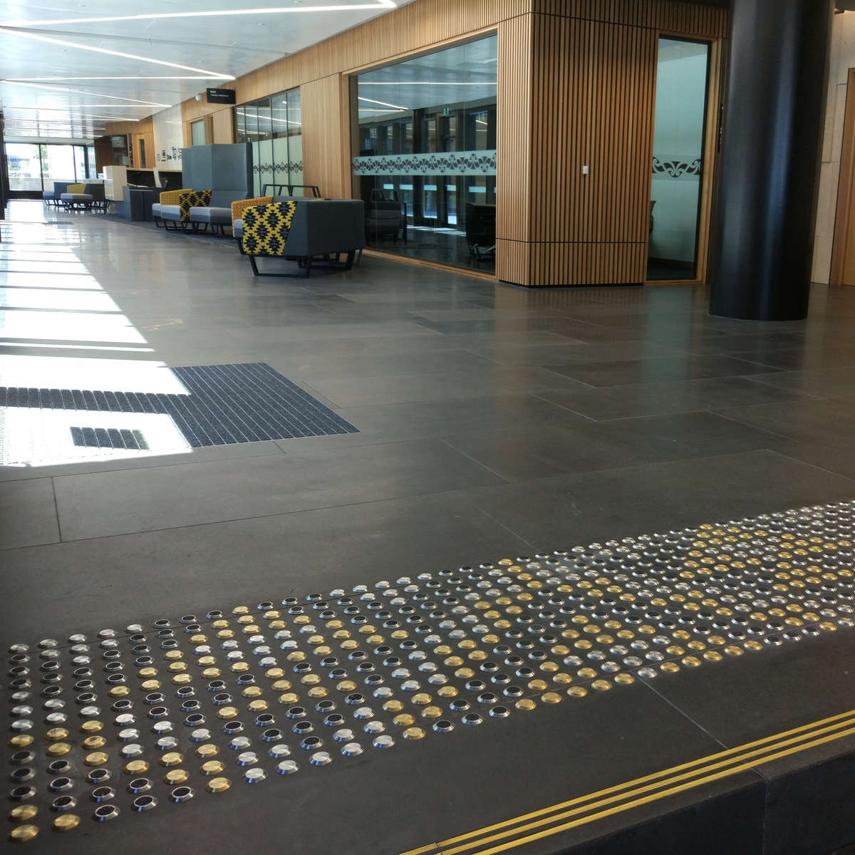 TacPro brass, stainless steel, and stainless steel with black carborundum arranged in a pattern at the top of stairs (3)