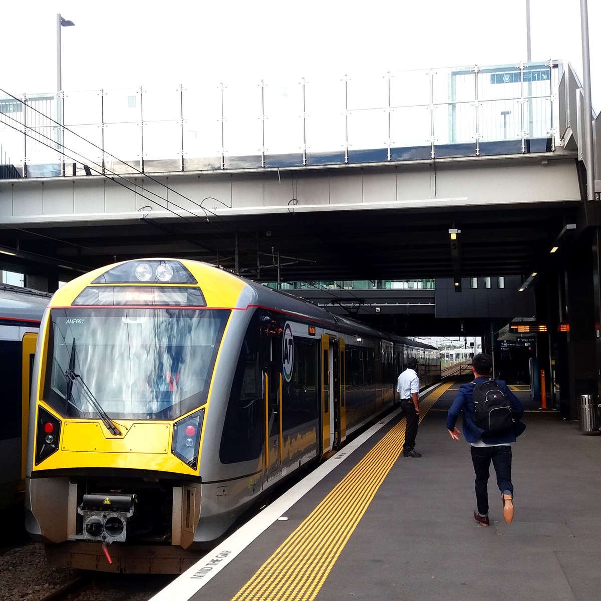 TacPro yellow polyurethane tactile indicators installed to the train station platform edge with a train at the station