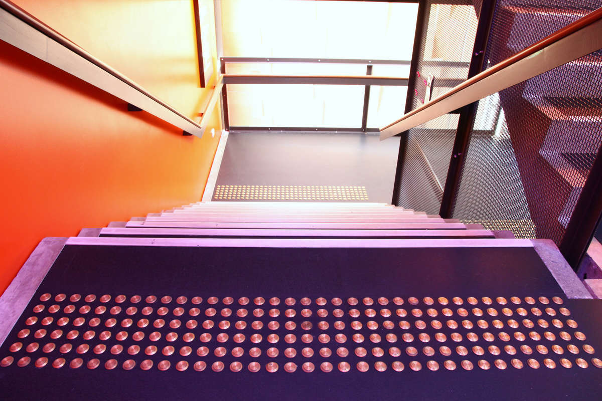 TacPro brass tactile indicators on lino at top and middle landing of stairs as viewed from the top