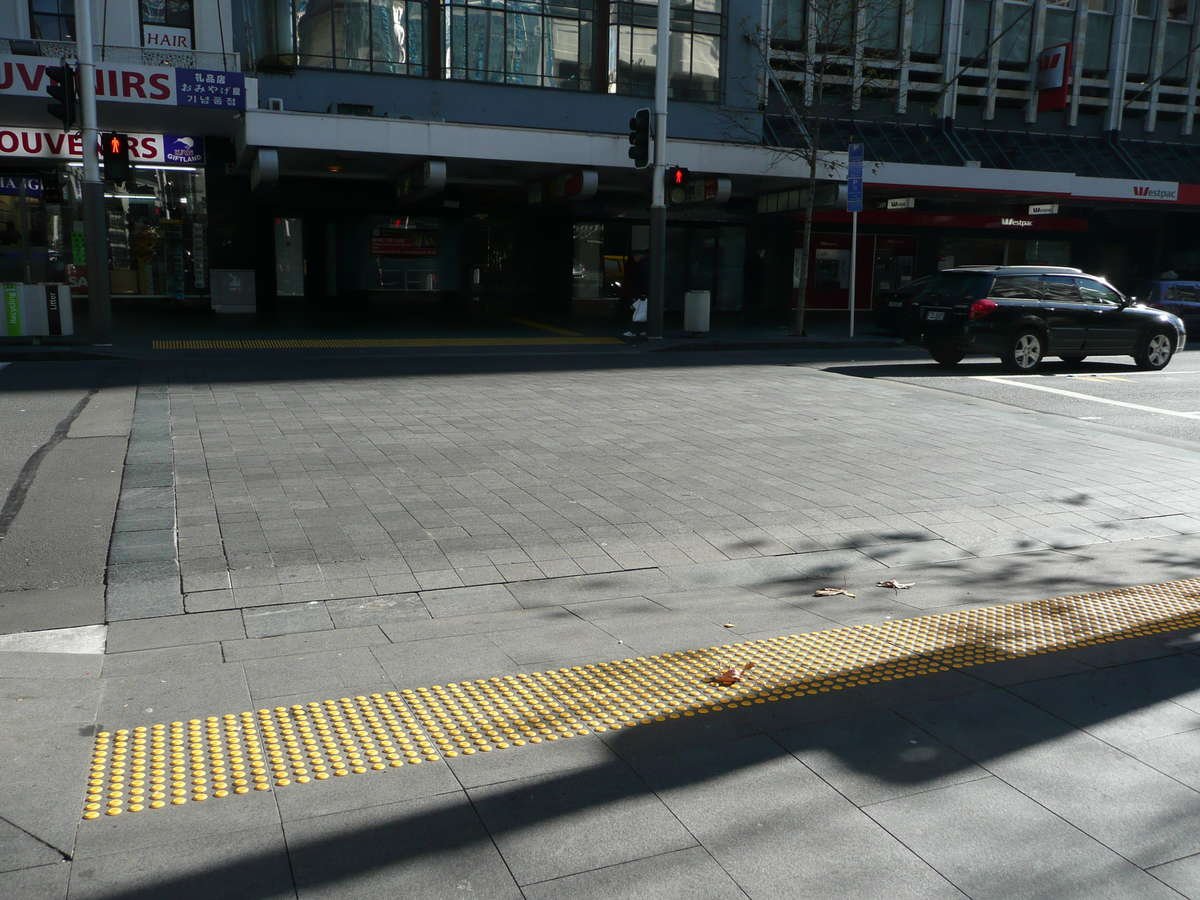 Yellow polyurethane tactile indicators on tiles at city pedestrian crossing