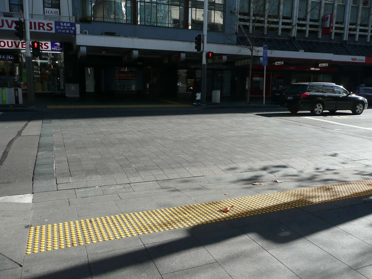 Yellow polyurethane tactile indicators on tiles at city pedestrian crossing