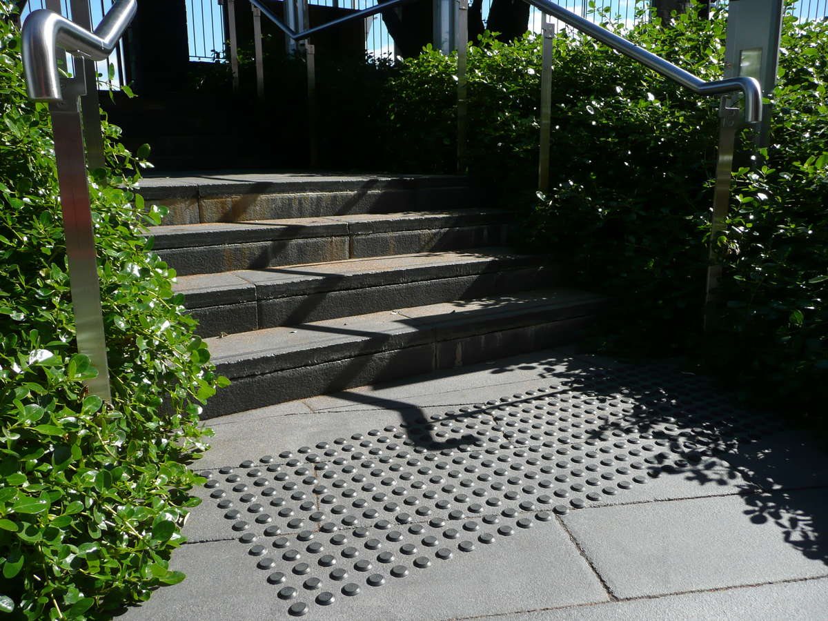 TacPro stainless steel tactile indicators installed on concrete at bottom of stairs