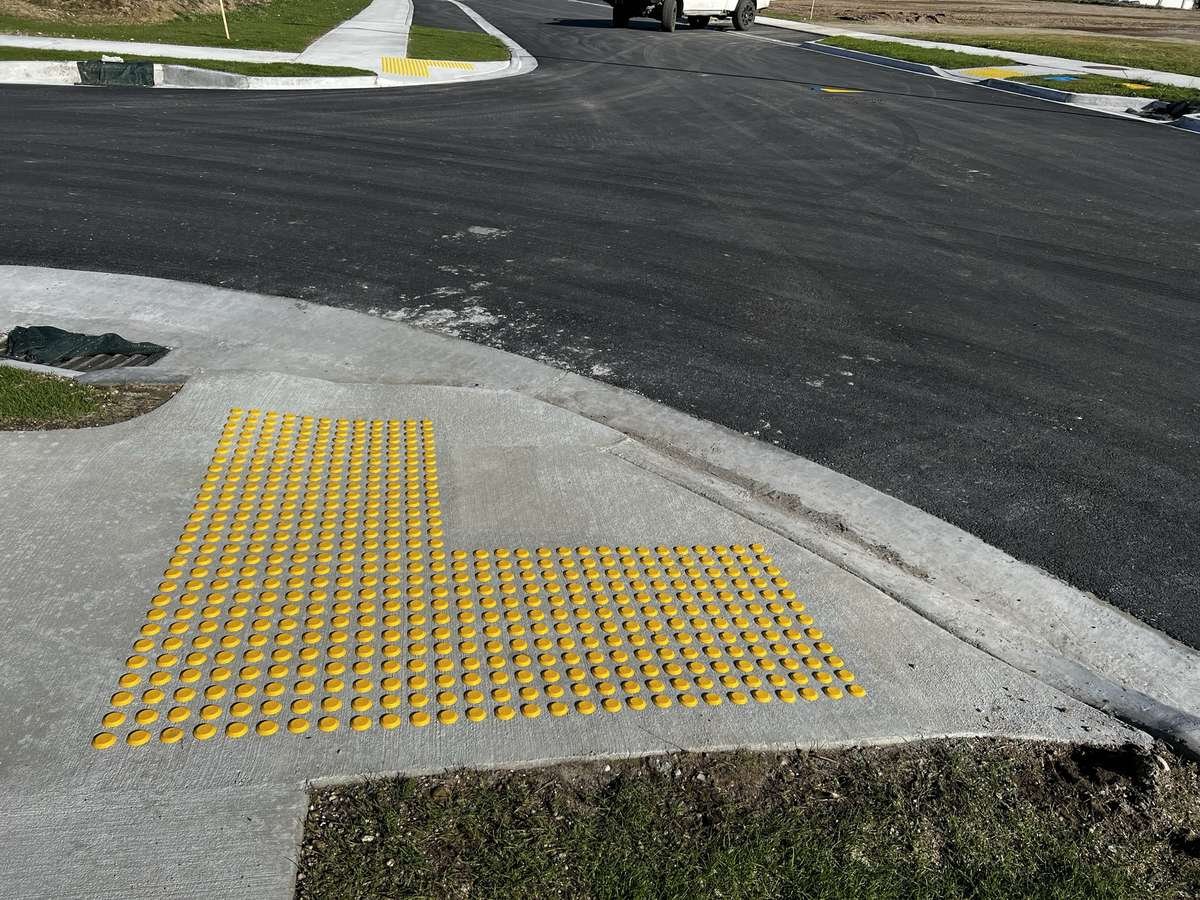 TacPro yellow polyurethane tactile indicators on concrete at a new subdivision pram crossing (2)