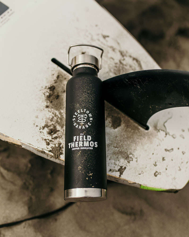 Aluminium Thermos with Hot Drink on Rock Stone Outdoors. Space for