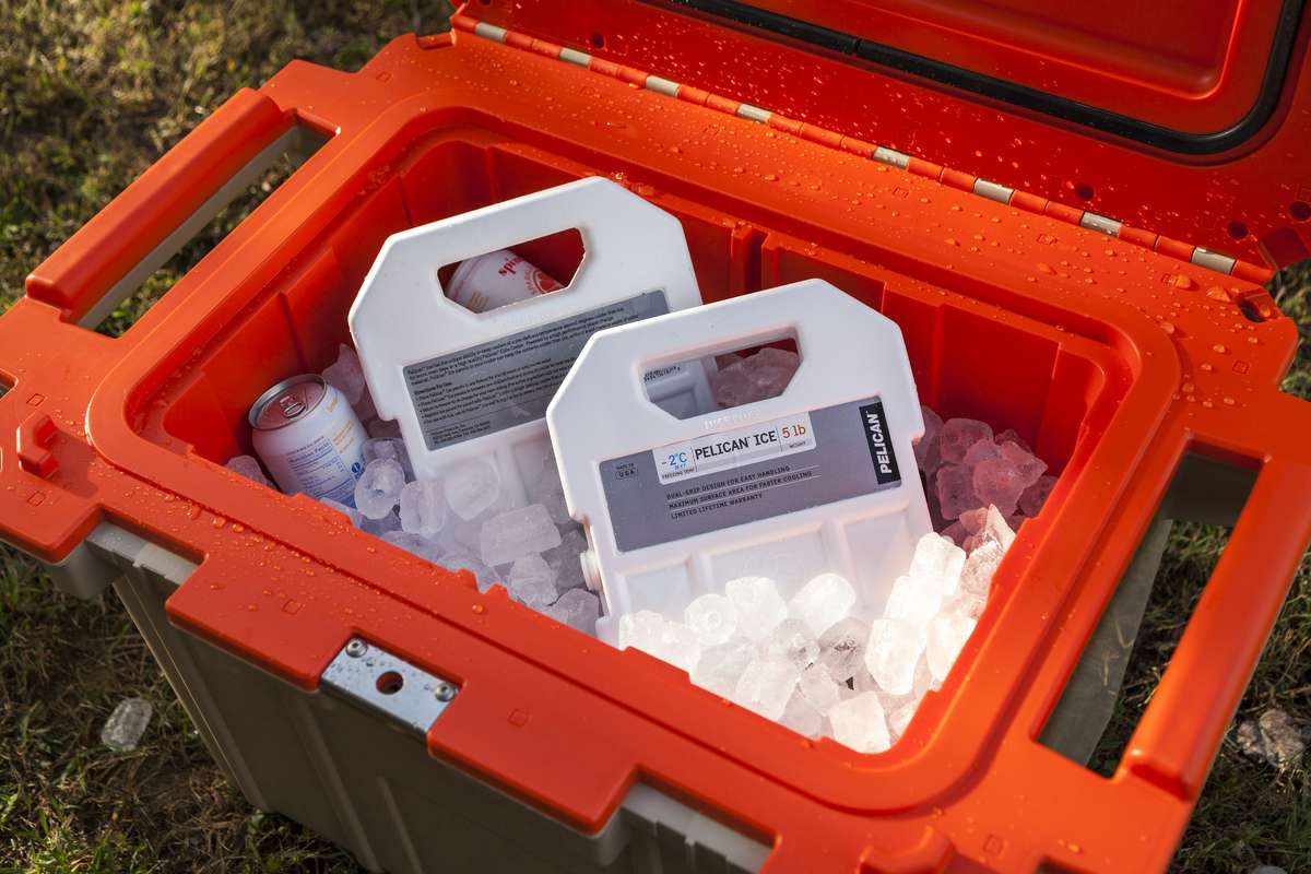 An open Pelican Elite Cooler filled with drinks, ice and two 5lb Pelican Ice packs.