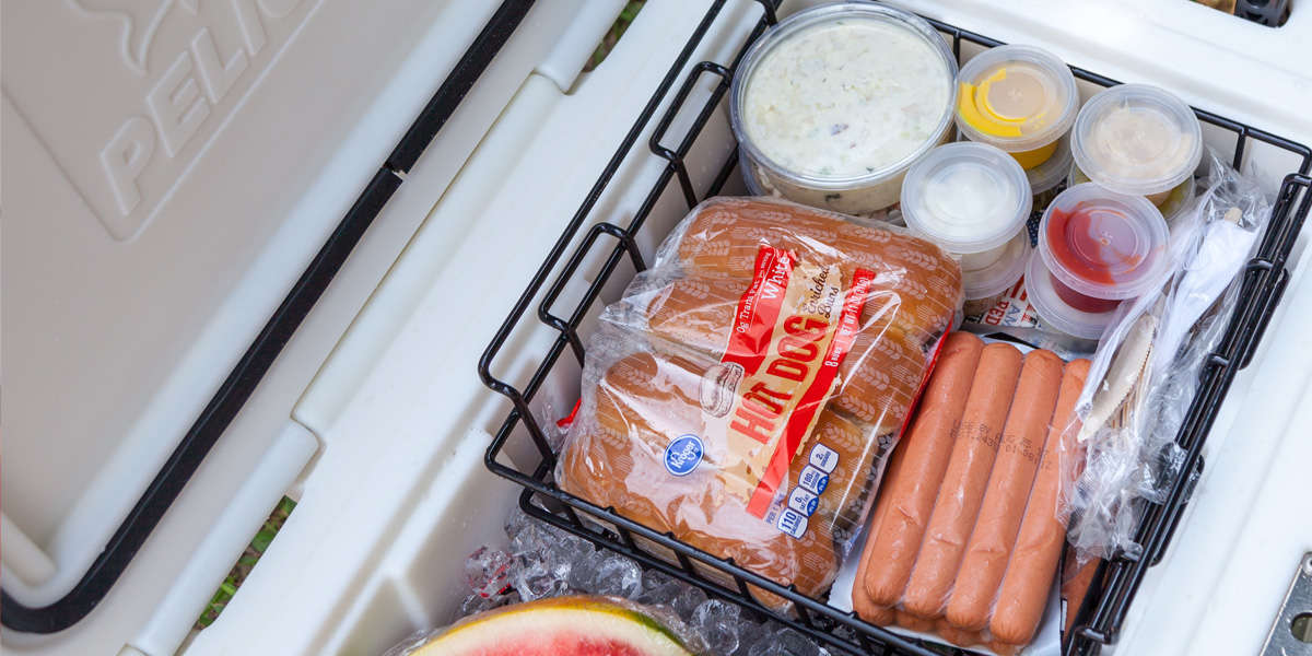 A packed cooler showing how to use a dry rack basket to protect delicate food. 