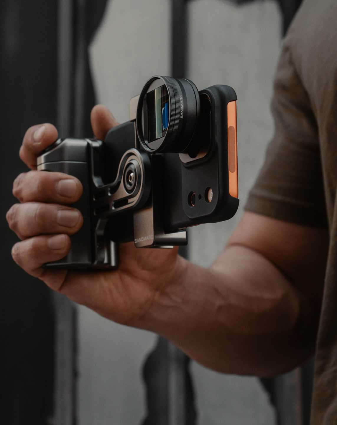 Person holding creator grip with iPhone attached.