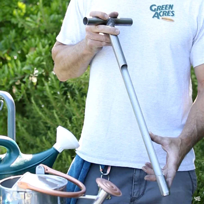 Green Acres employee holding a soil probe.