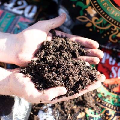 Hands holding rich, brown soil