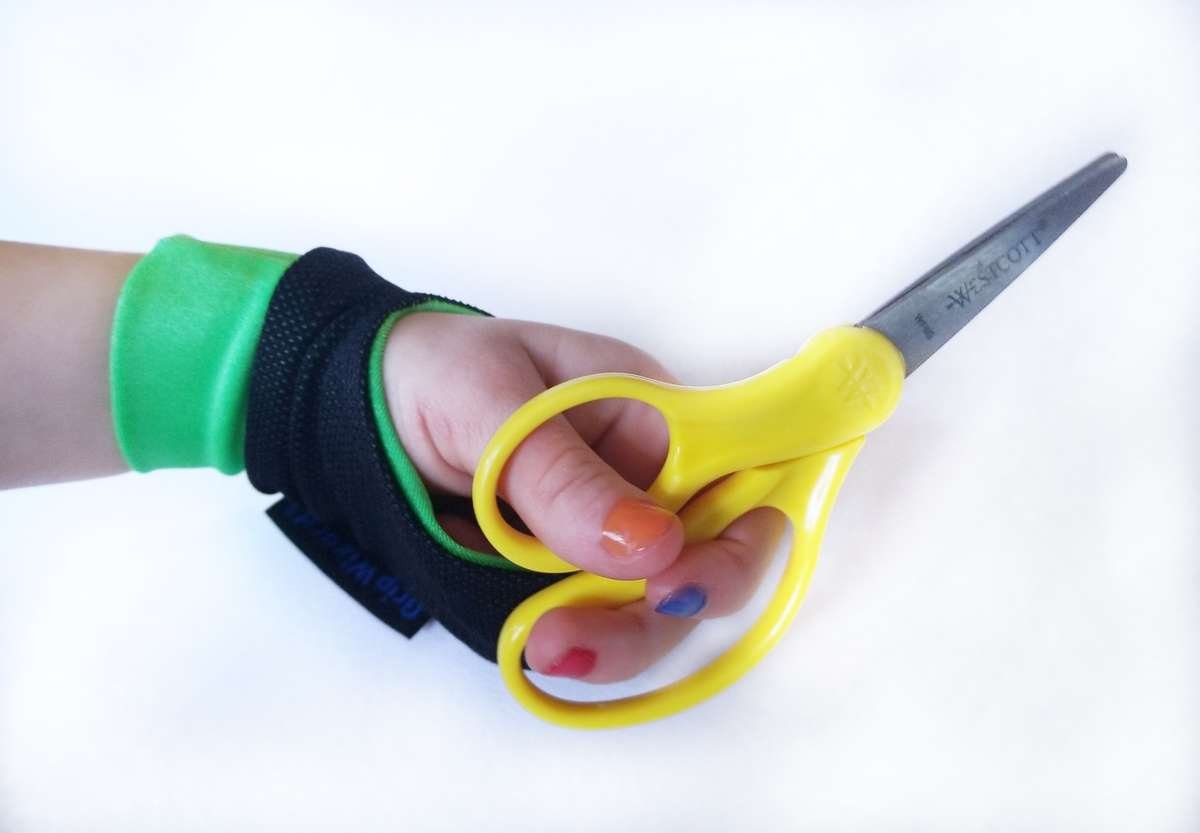 Child wearing Grip Wizard to help with scissor grip