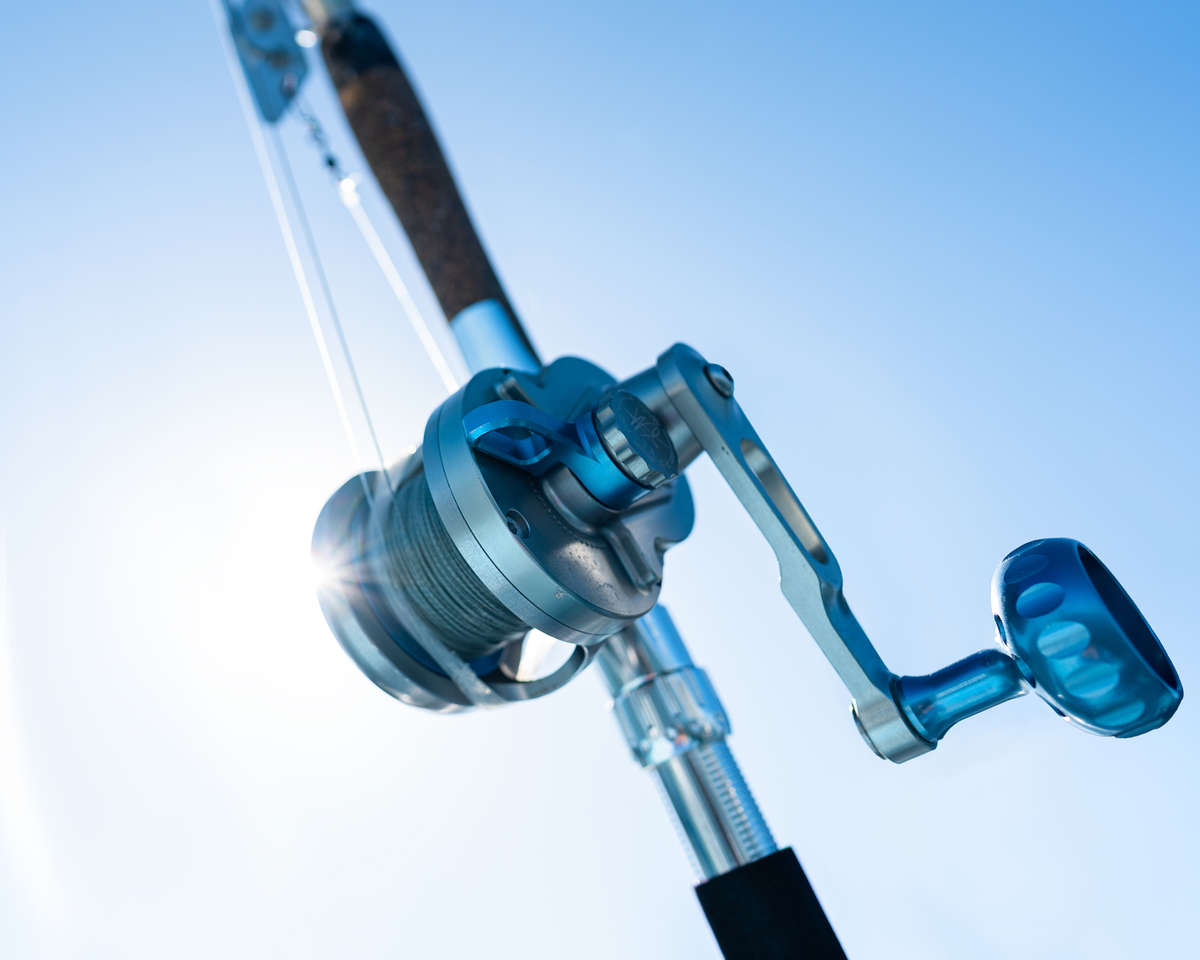 fishing reel and rod with sun in the background. fishing reel and rod with sun in the background.