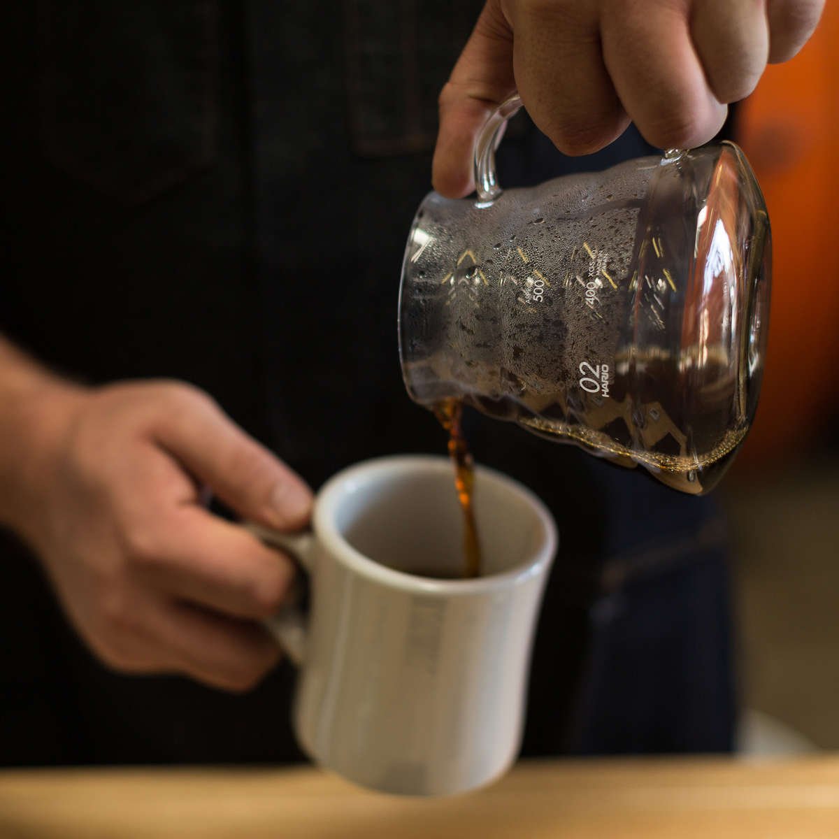Pouring brewed coffee into Bodhi Leaf mug