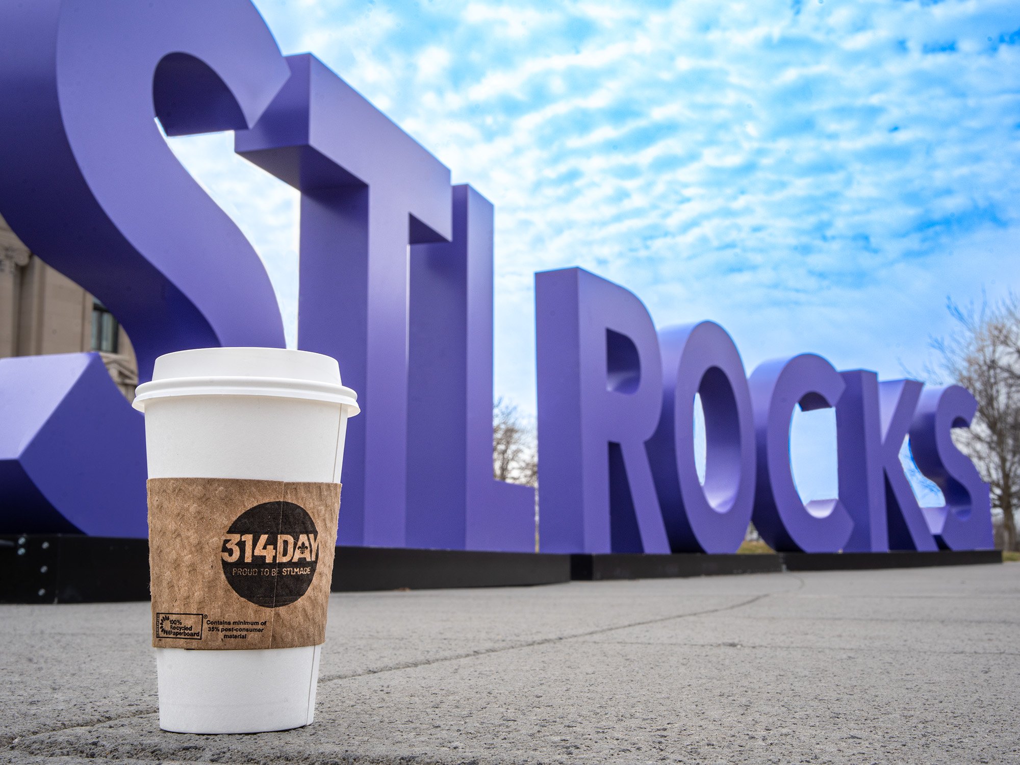 Hot cup in front of an STL Rocks sign