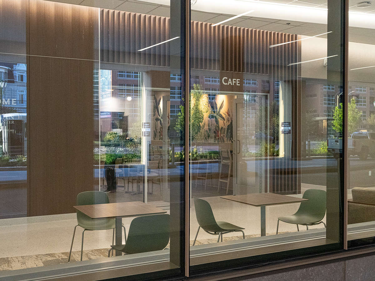 A view from outside the building, showing seating in the foreground, then a glimpse into the cafe's seating area