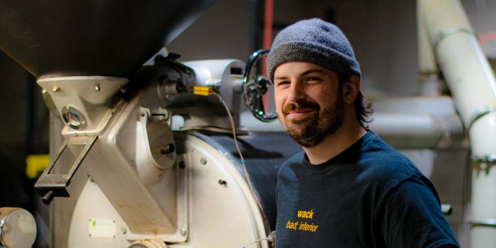 Jake Simorka standing by our vintage Probat coffee roaster