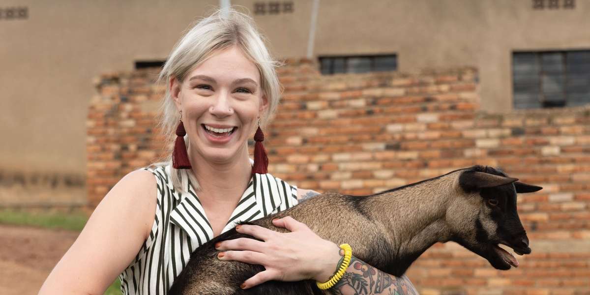 Kaldi's Team Member Kiersten holding a goat on our origin trip to Rwanda