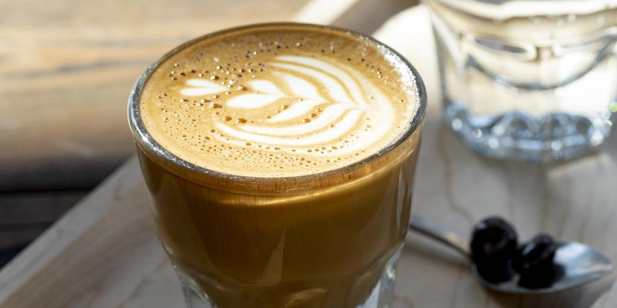 A Gibraltar coffee drink sitting on a wooden board