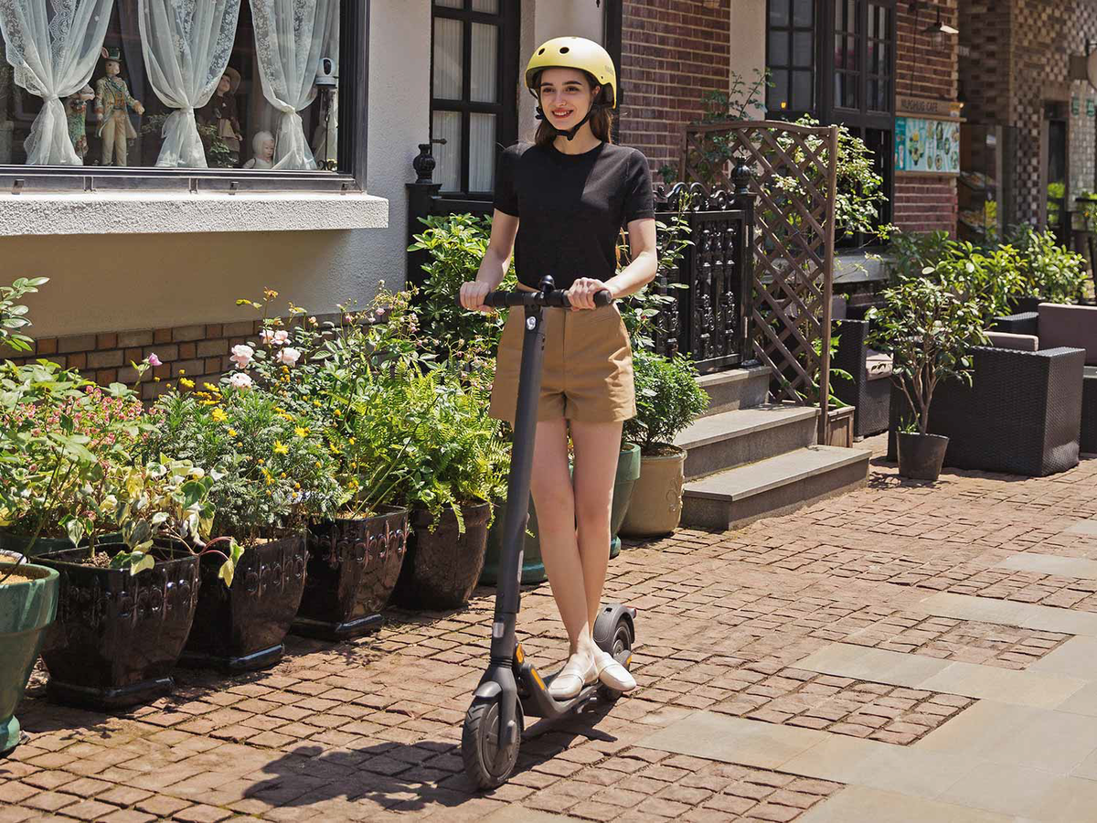 Girl Riding a Segway Ninebot KickScooter E45  on the Sidewalk