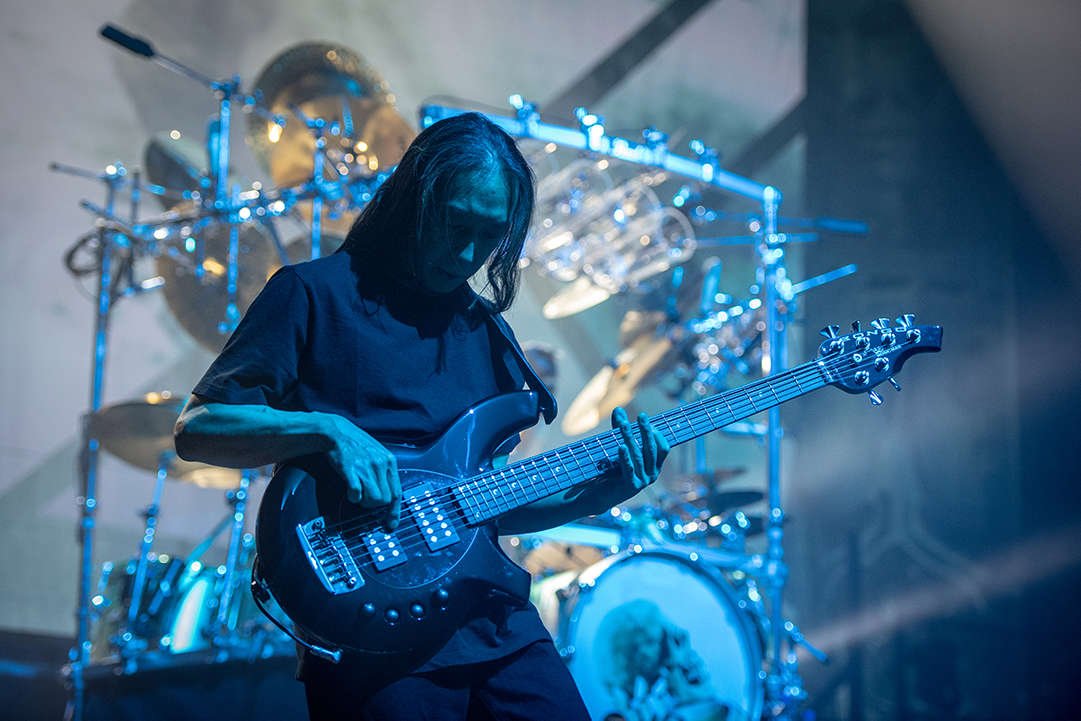 John Myung on stage playing his 6 sting bass guitar