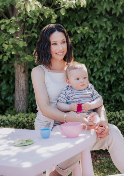 Health Lab founder Jess sitting outside with a baby on her knee