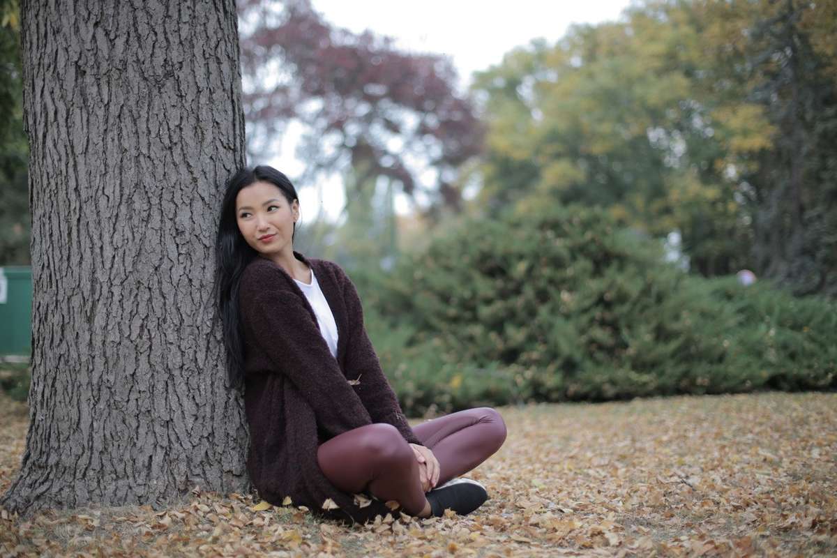 Woman sitting against a tree and relaxing