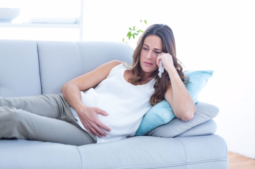 Pregnant woman on couch in contemplation