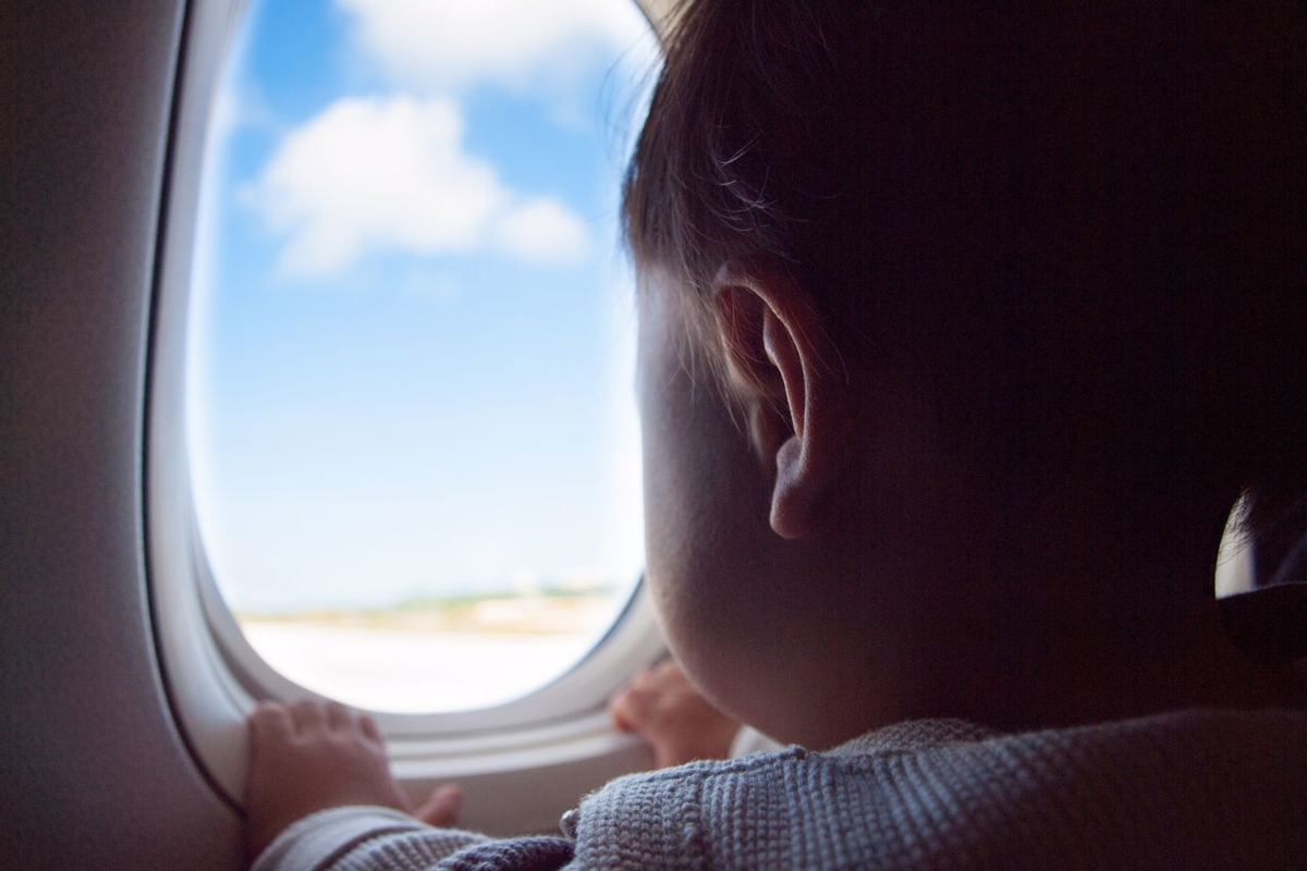 Child Gazing Out of Airplane Window